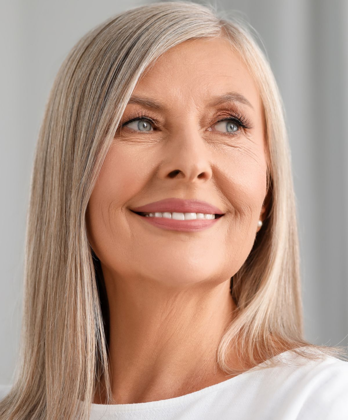 Smiling older woman with long, light gray hair.